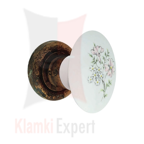 Klamka FLAVIA 686, porcelana biała z kwiatem Margherita, rozeta 103 AN patynowany antyczny