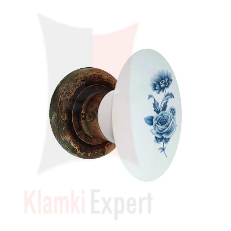 Klamka FLAVIA 681, porcelana biała z kwiatem niebieskim, rozeta 103 AN patynowany antyczny